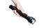 A right hand is holding a black, elongated torch that is switched on and shining downwards.