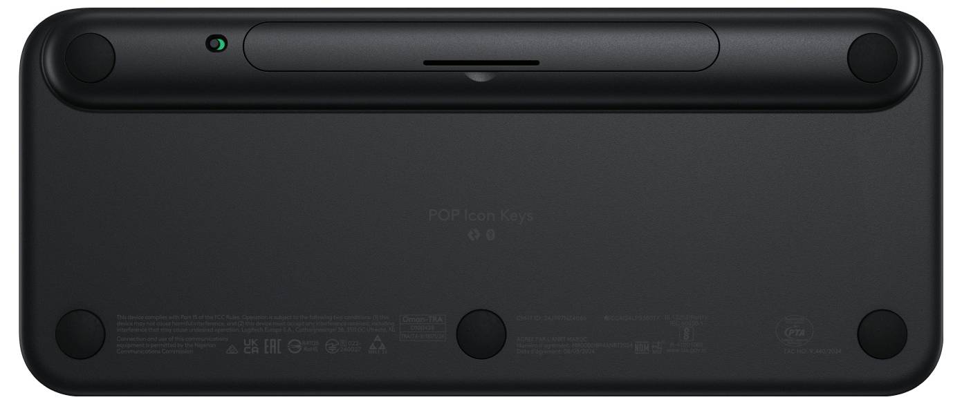 The rear of a black keyboard with round rubber feet at the corners and a visible power button in the top left corner.<br><br>Note: The translation is already in British English, so no significant changes were needed.