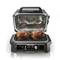 A modern tabletop oven with an open lid, two whole chickens on the grill rack and a digital display screen.