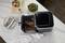An air fryer with an open basket displays roasted meat and potatoes. Alongside it sits a fresh salad and cutlery.