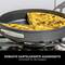 A pan on a hob with a piece of vegetarian frittata. Text below: 'Robust hard-anodised exterior - Developed to last a lifetime'.