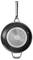 Black frying pan with a metal handle and silver reverse side, hanging on the wall, shows the design of the pan's underside.