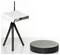 'A white Wi-Fi router on a stand next to a black round base station on a table.'