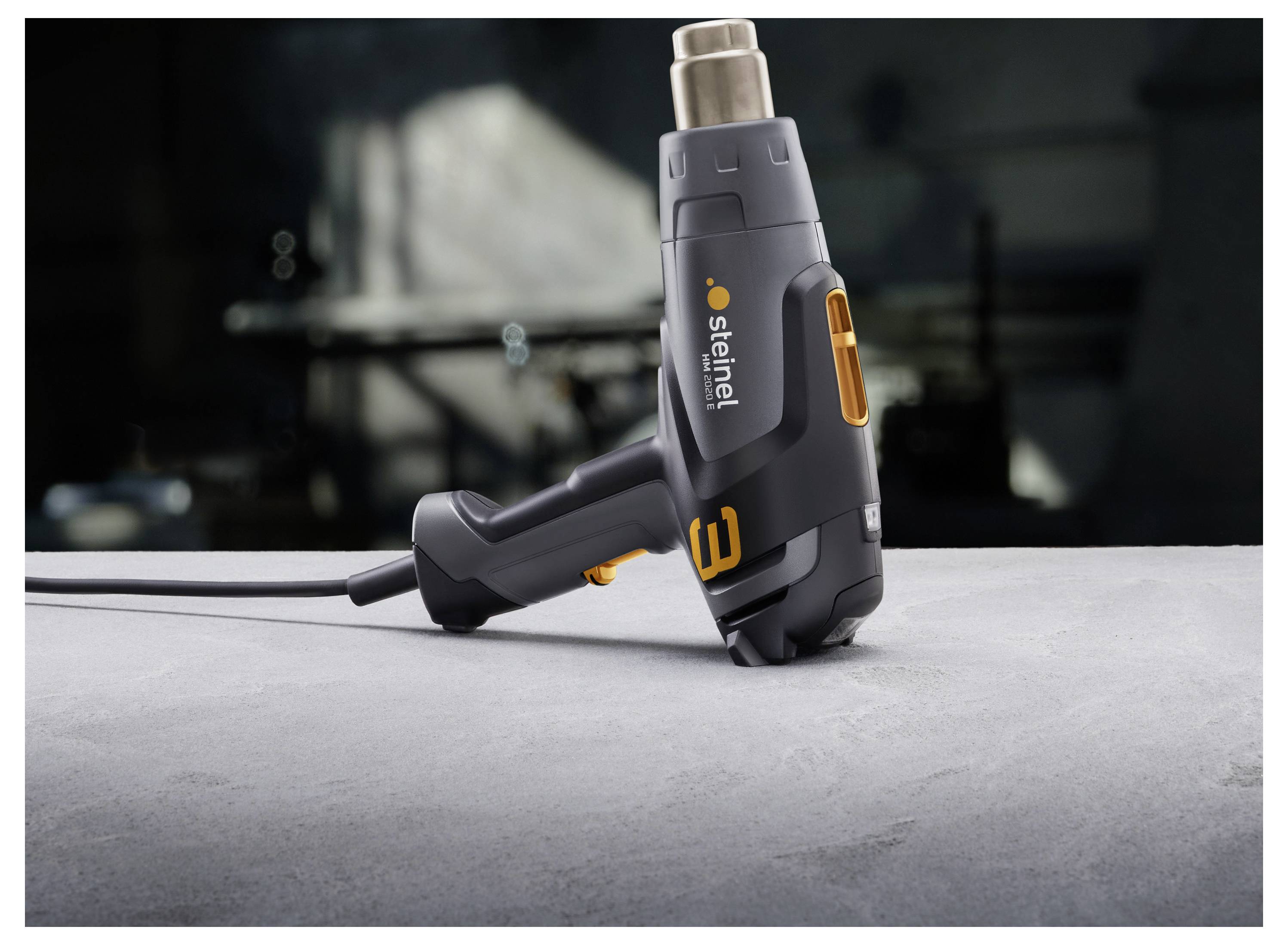 Cordless steinel heat gun standing on a work surface in a workshop.