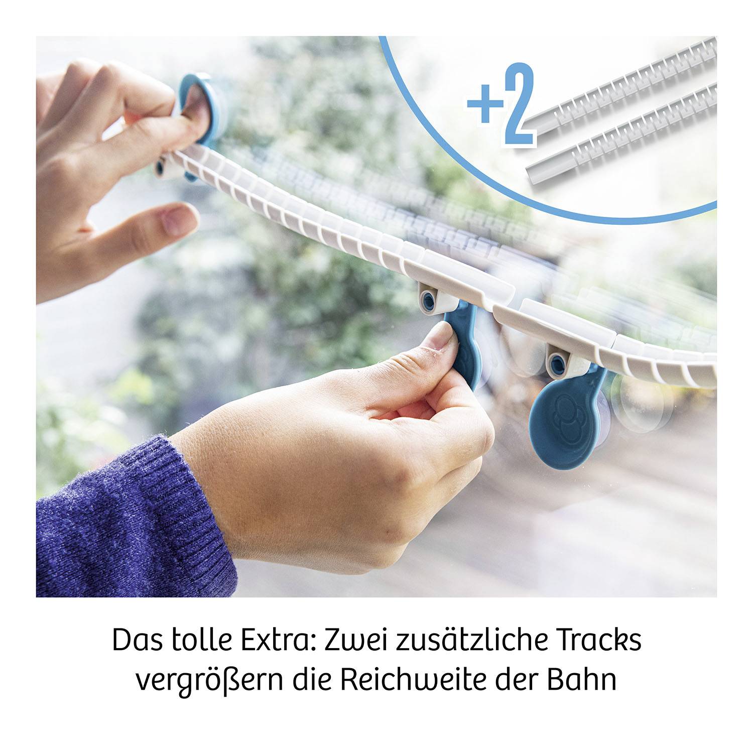Two hands add two additional tracks to a railway. Text: 'The fantastic extra: Two additional tracks increase the railway's range'.