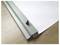 A white sheet of paper partially rolled into a silver metal strip on a wooden table.