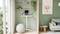 Standing desk with laptop and monitor in a minimalist room with green walls, plants, and a sitting ball, next to a window with daylight.