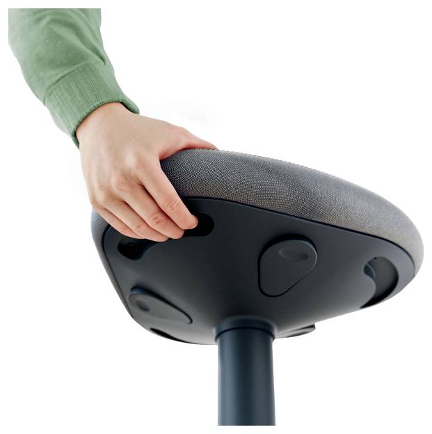 A hand reaches for the underside of a modern stool with adjustable functions. The stool has a padded seat.