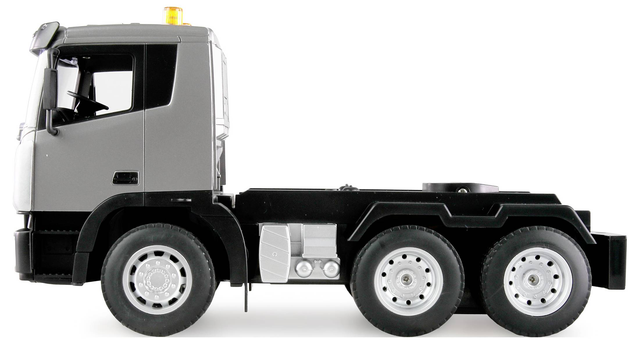 Grey lorry without a trailer seen from the side, six wheels visible, yellow warning light on the roof.
