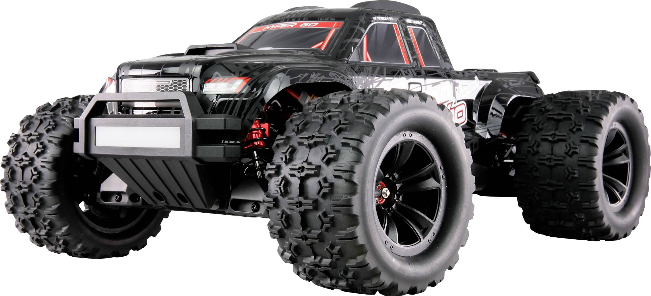 Toy RC truck with large rubber tyres and a black chassis, displaying red details, driving forward on a white surface.