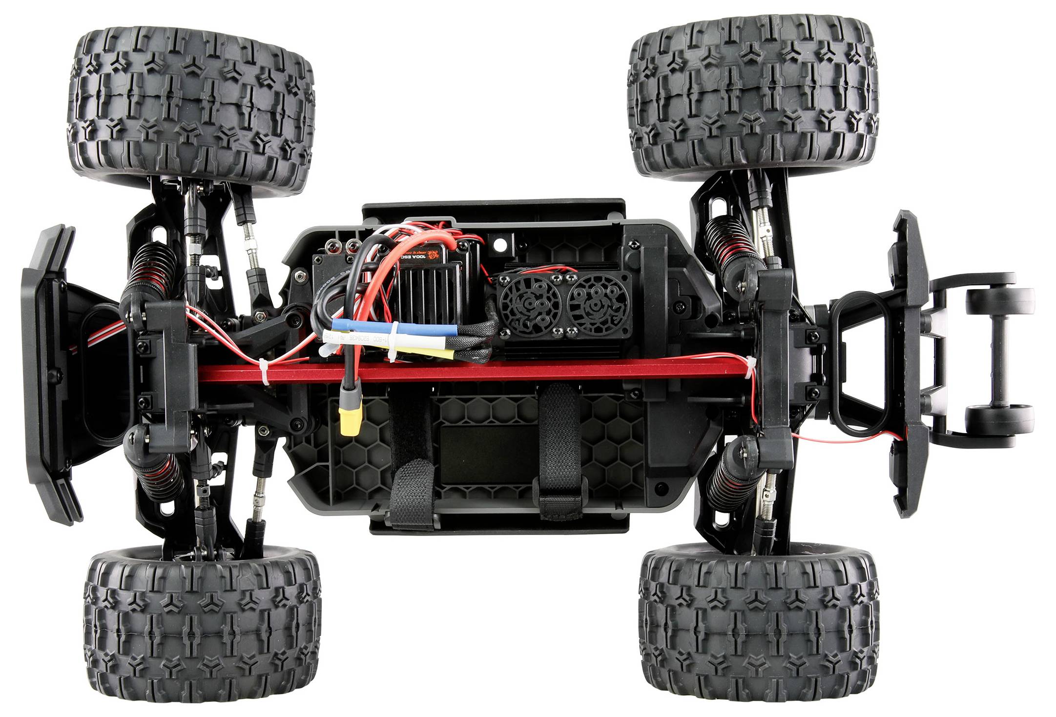Open chassis of a remote-controlled car, showing engine, cables and large treaded tyres, ready for assembly.