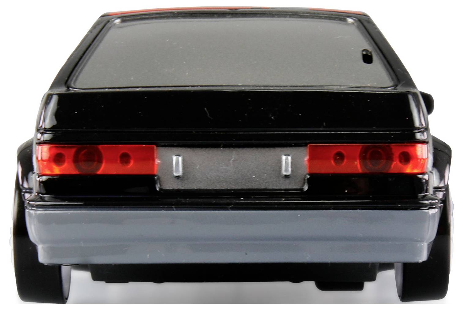The image shows the rear view of a black toy car with red tail lights on a white background.