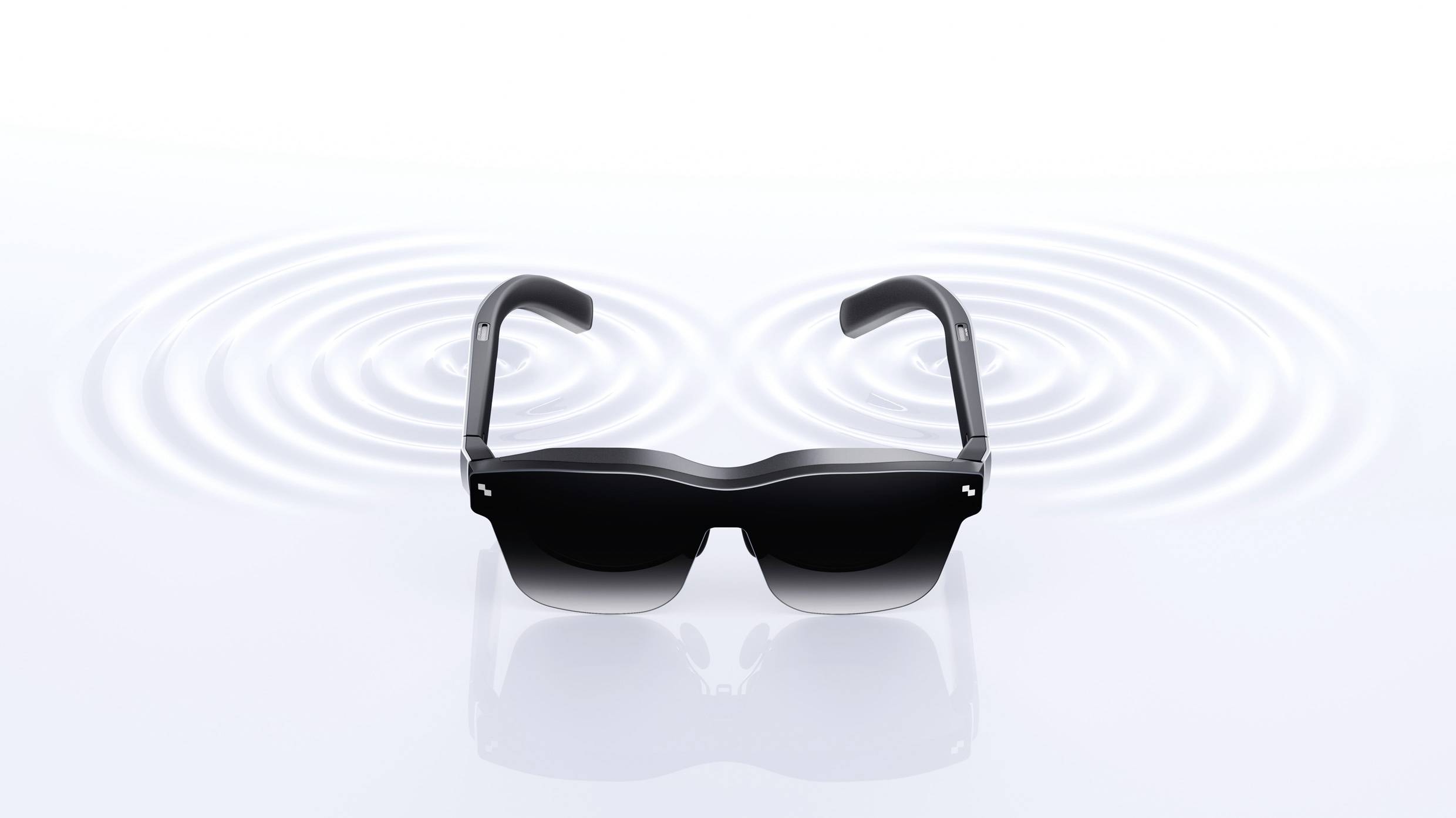 A black pair of sunglasses rests on a smooth surface, surrounded by concentric wave patterns in the background.