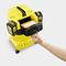 A hand removes a filter from a yellow vacuum cleaner. The vacuum cleaner is standing against a light background.