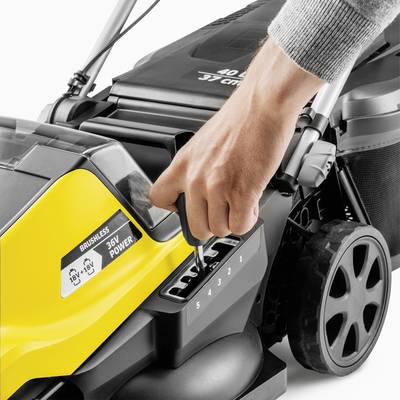 A hand adjusts the cutting height of a yellow lawnmower with six adjustment levels. The mower is partially electric.