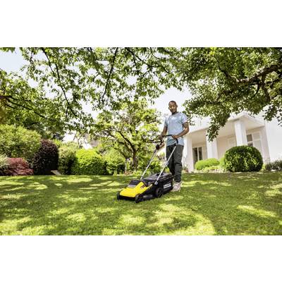 A man is mowing the lawn in a green garden with a yellow lawnmower. A white house can be seen in the background.