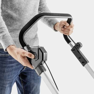 A person is holding a vacuum cleaner handle with both hands. The focus is on the handling of the device used for floor cleaning.