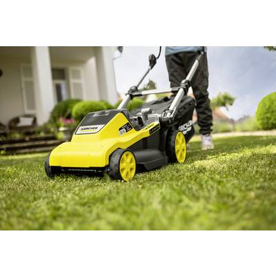 A person is pushing a yellow lawnmower over freshly cut grass in front of a house with white columns and green bushes.