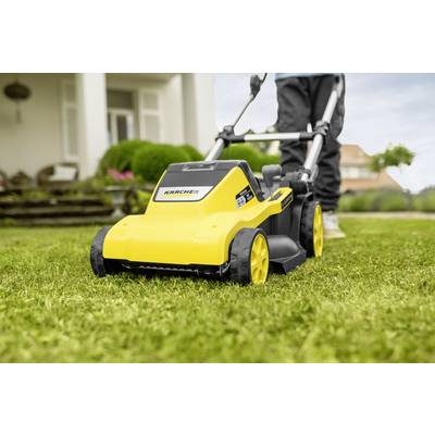 A person is mowing the lawn with a yellow lawnmower in a garden in front of a house.