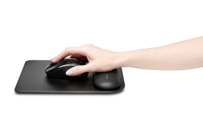 'Hand on a black computer mouse, resting on a mousemat.'