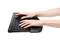 A person is typing on an ergonomic keyboard with a wrist rest.