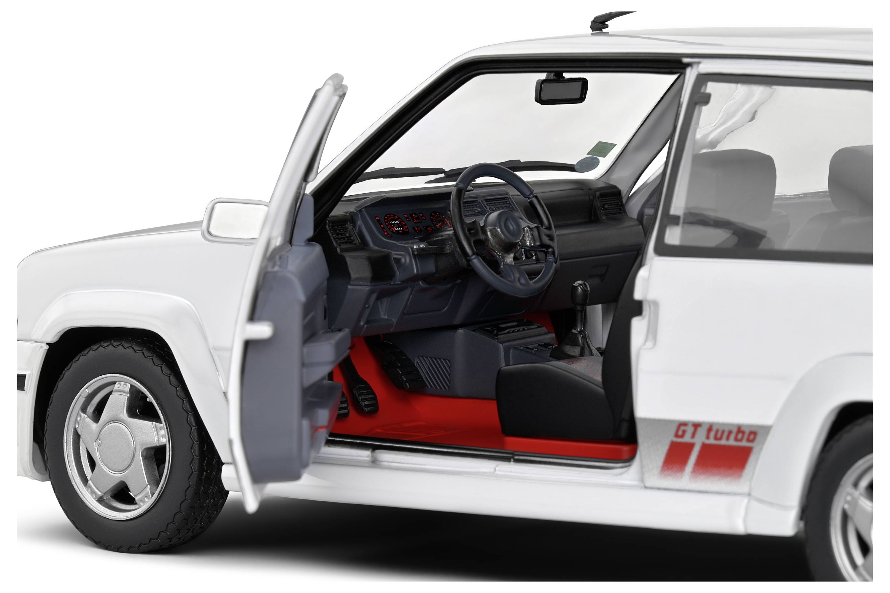 A white car with an open driver's door reveals its interior. The door reads 'GT turbo'.