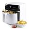 A white air fryer with a digital display and control panel. Fresh chips are in the drawer and served in a white bowl.