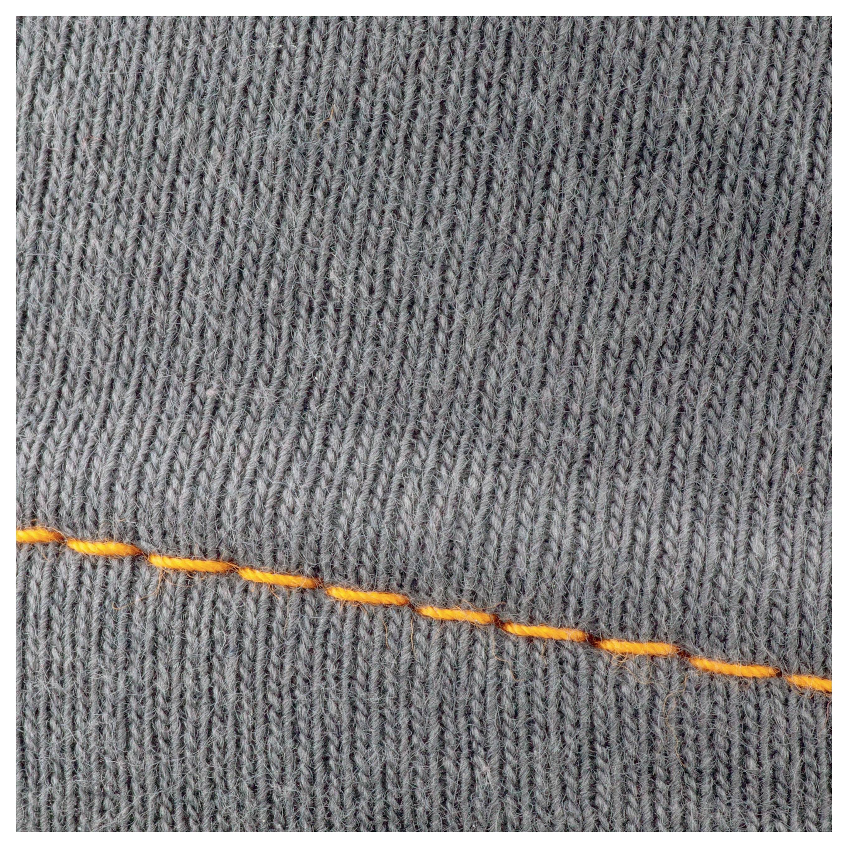 Grey knitted fabric with a diagonal, orange seam.
