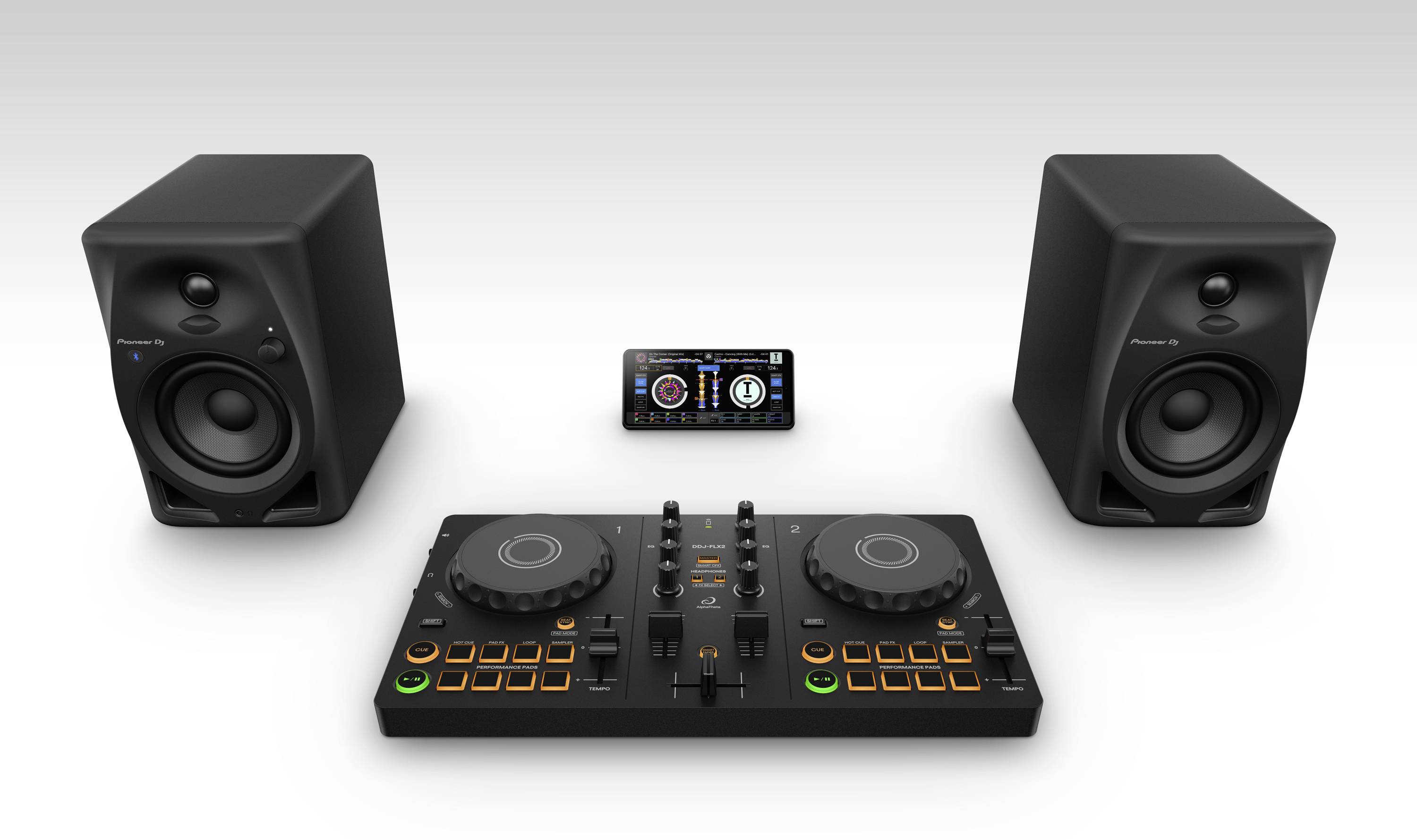 DJ controller with two turntables, headphones and speakers beside it. A smartphone displays a music control app.