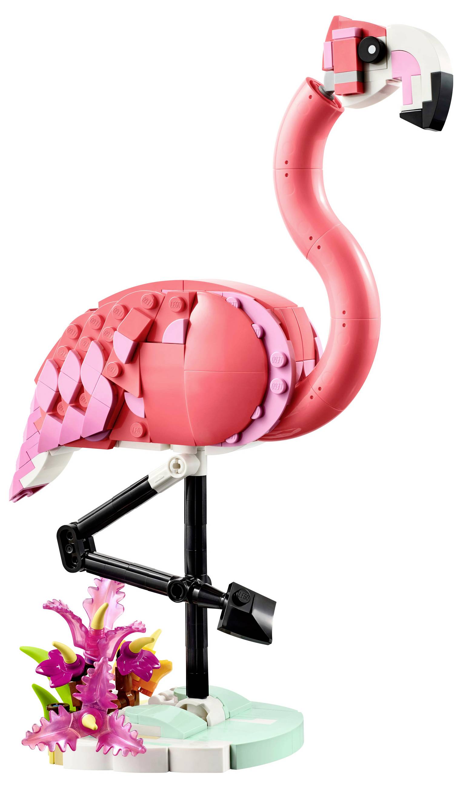 A LEGO flamingo stands on one leg, surrounded by pink flowers on a round, green base.