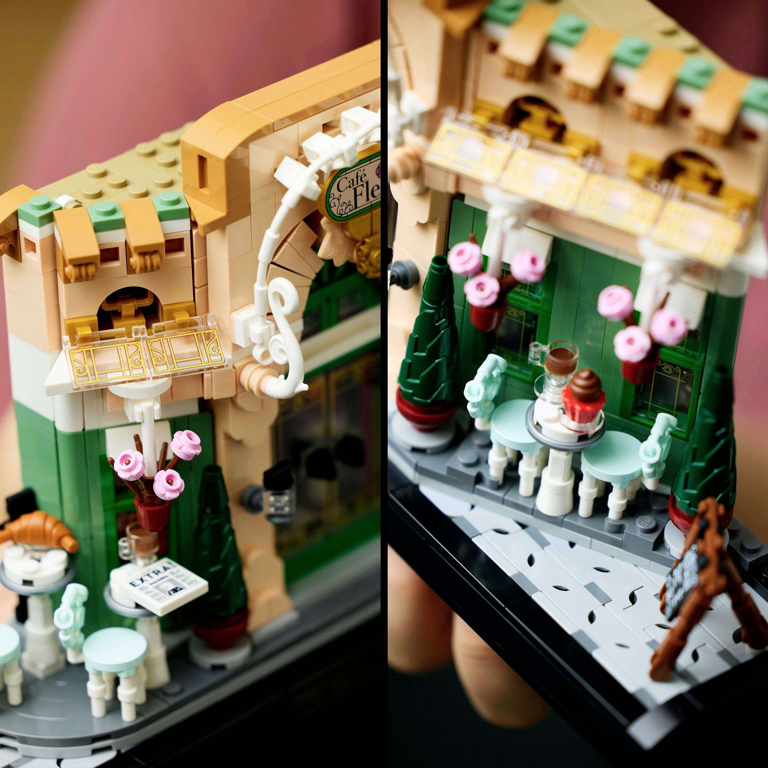 A detailed model of a café building made of building blocks, with tables and decorations such as flowers. A sign reads 'Café'.