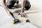 A person is laying laminate flooring, using a rubber mallet for precise placement. Hands and tool in focus.