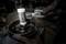 A mechanic is working on a metal part on a workbench using a white rubber mallet. Tools and car parts are visible in the background.