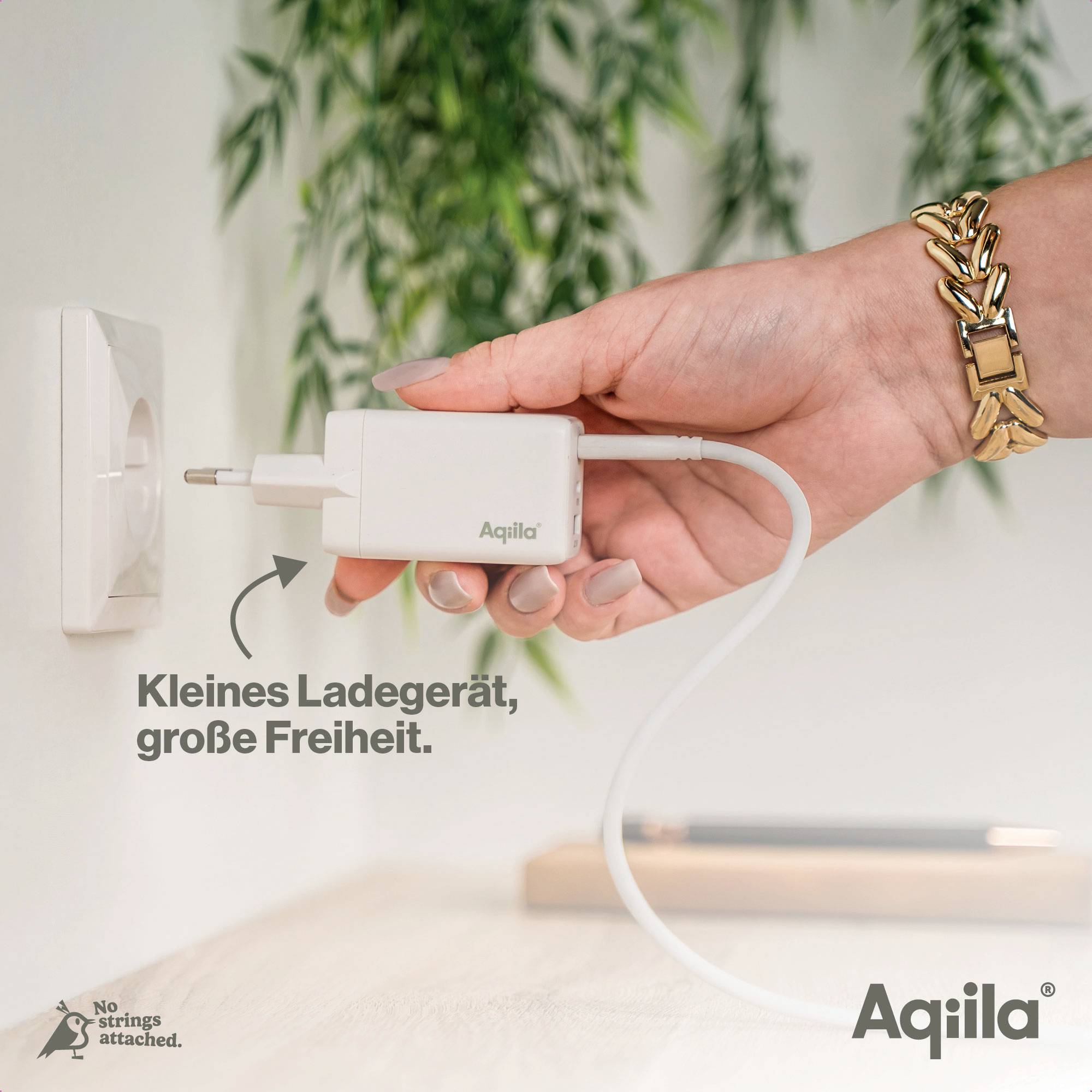A hand plugs an 'Aqila' brand charger into a socket. Text: 'Small charger, great freedom'.