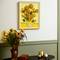 A room with a sunflower bouquet on a table and an artwork featuring sunflowers on the wall. Harmony of art and nature.