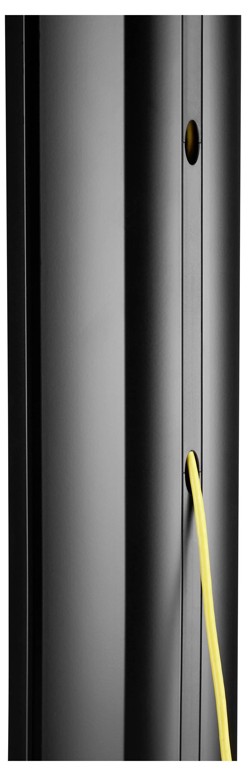 A black, vertical speaker tower with a yellow cable inserted into an opening on its side.