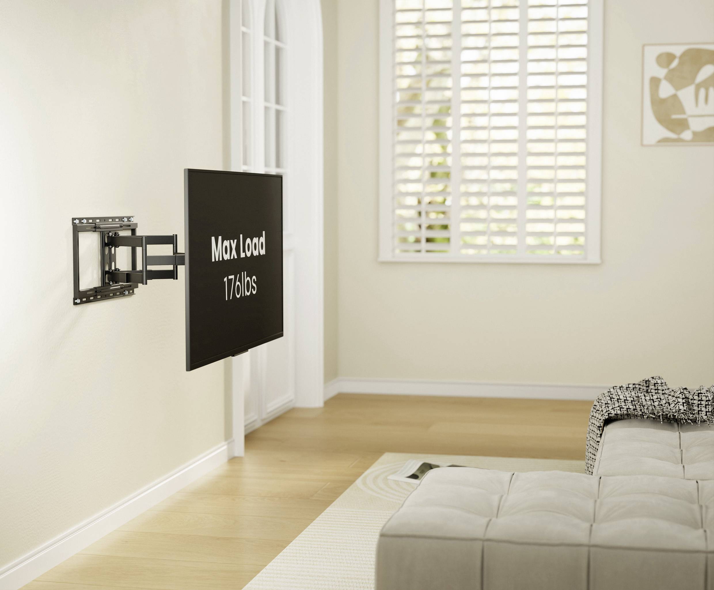 Flat-screen wall mount installed, displaying a screen with the text 'Max Load 176 lbs', in a bright living room with a sofa.