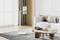 Modern, minimalist living space with grey carpet, wooden coffee table and light-coloured sofa. Flat screen on standing mount to the left.