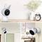 Security camera with bunny ears sitting on a table beside a vase and clock, cameras below in living spaces, safety for children's bedrooms.