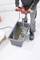 A person is mixing cement or concrete with an electric mixing tool in a rectangular container.
