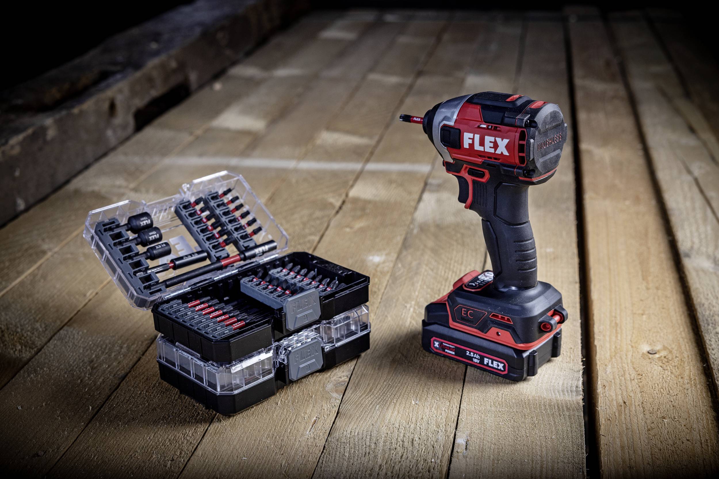 Cordless drill with 'FLEX' logo and matching bit set placed on wooden floor. Perfect for construction projects and repairs.