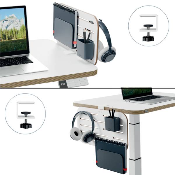 Laptop on an adjustable-height desk with a wall-mounted whiteboard, headphones, and writing materials; focused on organisation.