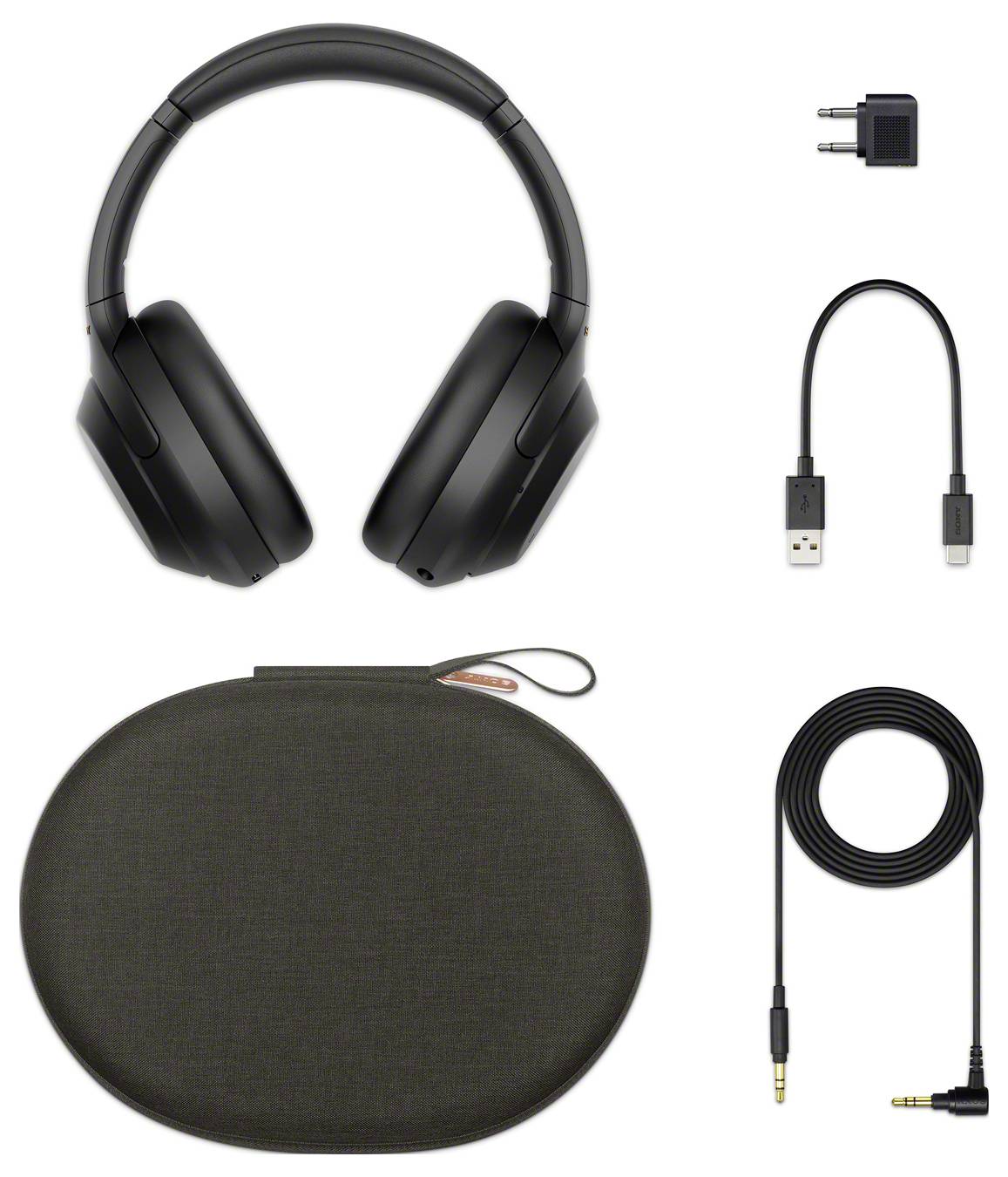 Black wireless headphones with ear cushions, rechargeable USB cable, adapter, 3.5mm audio cable and black carry case.