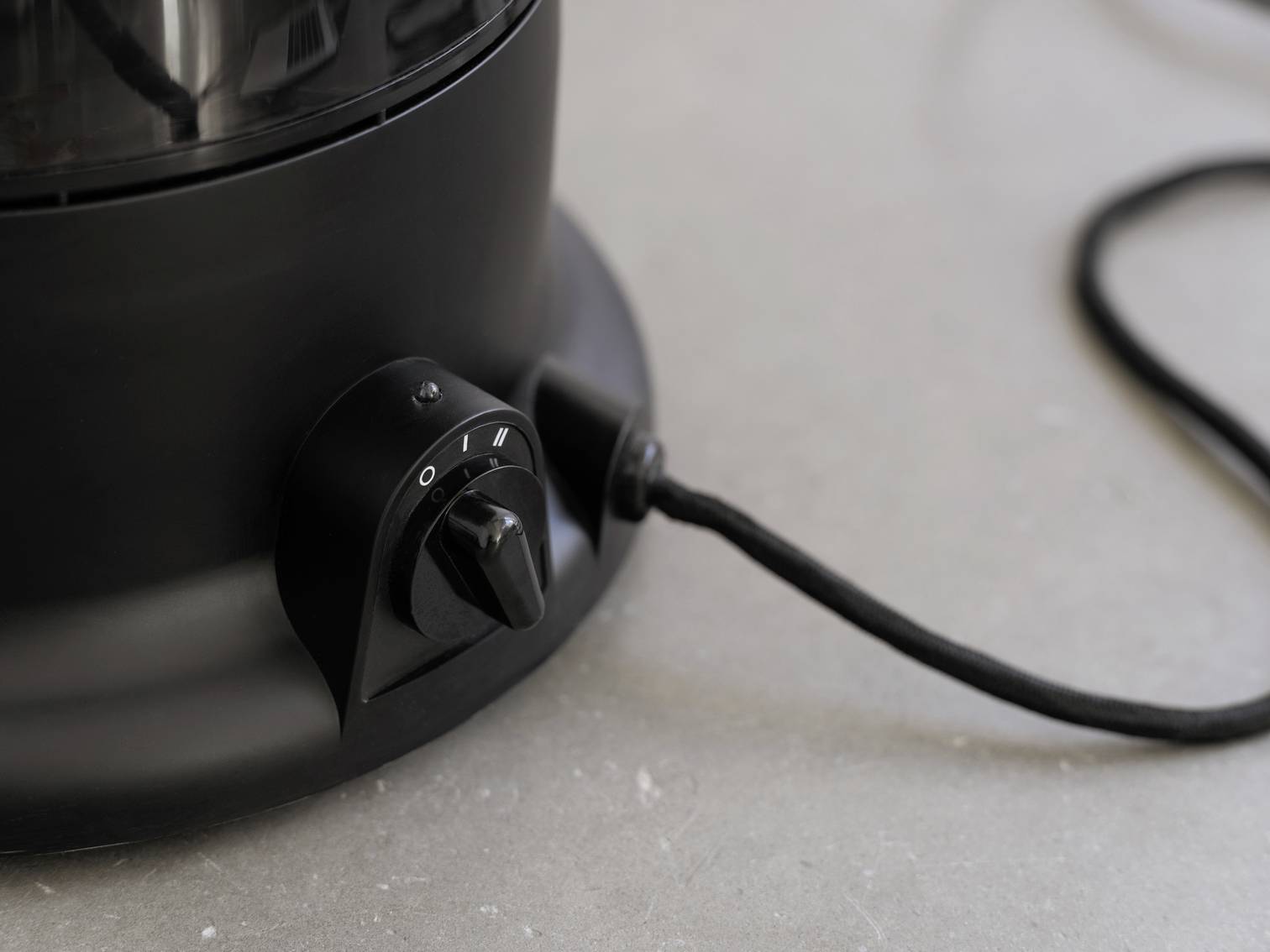 A black rotary switch on an electrical device is pointing to '0'. A power cable is connected to the side.