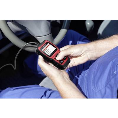 A person wearing blue clothing sits in a car and holds a diagnostic device in their hand. The screen displays vehicle data for fault analysis.
