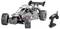 'A remote-controlled car with off-road tires and a large rear spoiler, positioned next to its black remote controller.'