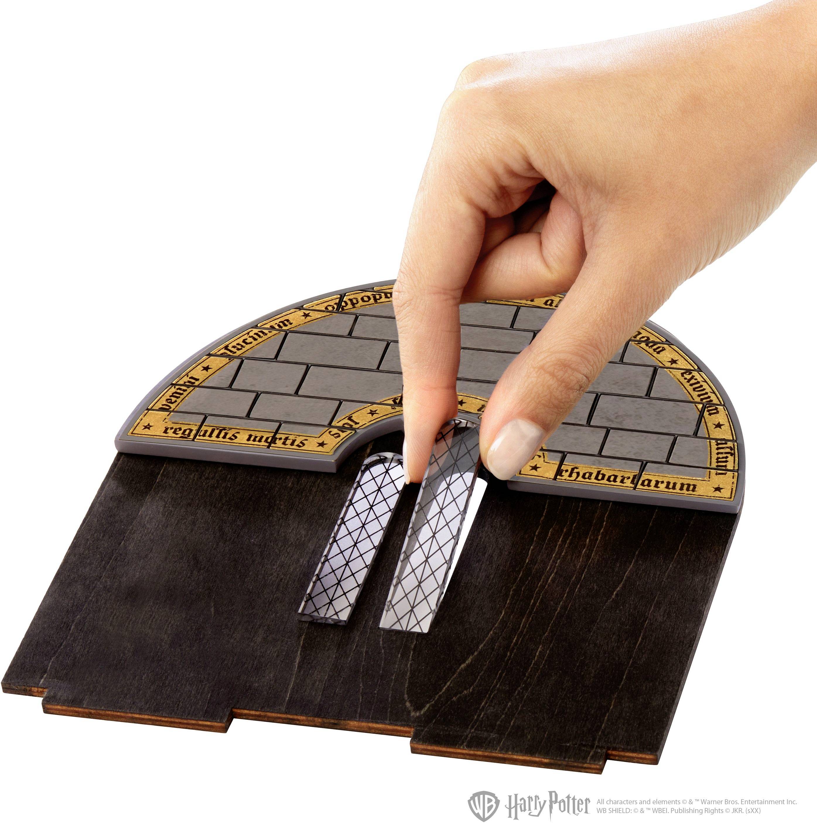 A hand moves a rectangle through a maze on a wooden board with Latin inscriptions along the edge.