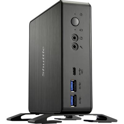 A black mini PC standing upright with USB ports and audio ports on the front. Brand name 'Shuttle'.
