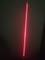 A straight, red laser beam shines vertically against a dark background. The beam is clear and intense.