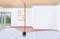 A laser device projects red lines onto the wall and ceiling of an empty room to mark straight lines for construction or renovation work.
